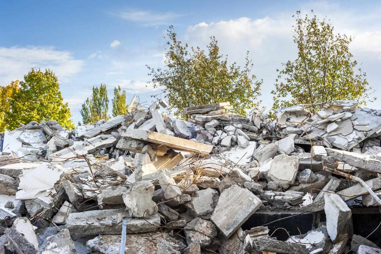 Pile of demolished concrete waste with exposed reinforcement ready for aggregate recycling
